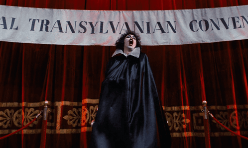 Woman in Black Cape in Front of Transylvanian Convention Banner
