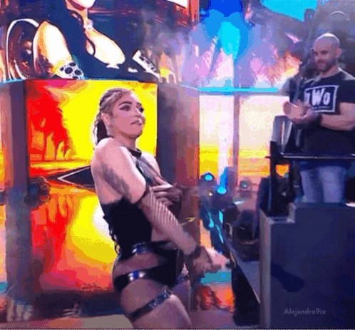 Woman in Black Dancing on Stage with Large Screen
