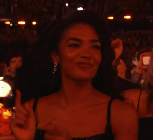 Woman In Black Dress And Earrings Smiling GIF