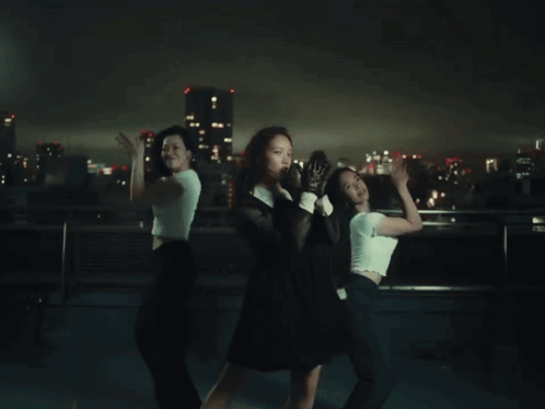 Woman in Black Dress and White Gloves Dancing with Two Women