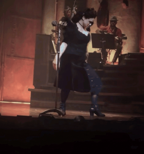 Woman in Black Dress at Microphone