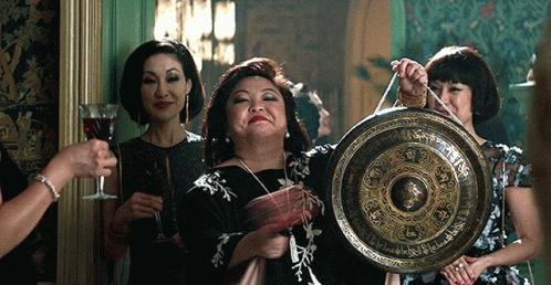 Woman in Black Dress Holding Gong With Chinese Writing
