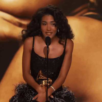 Woman In Black Dress Holding Grammy At Microphone GIF