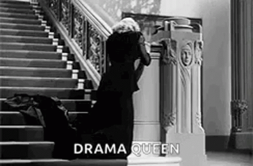 Woman In Black Dress Kneeling On Stairs Black And White GIF