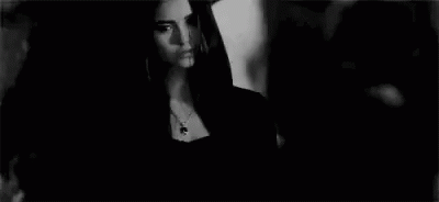 Woman In Black Dress Next To Man In Black And White GIF