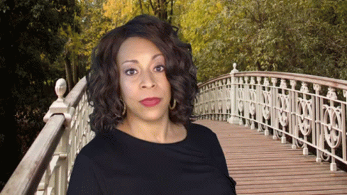 Woman in Black Dress on Wooden Bridge