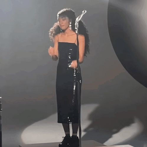 Woman In Black Dress Singing Into Microphone GIF