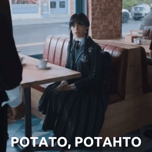 Woman In Black Dress Sitting At Table GIF