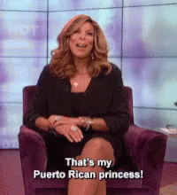 Woman in Black Dress Sitting in Purple Chair Saying That's My Puerto Rican Princess