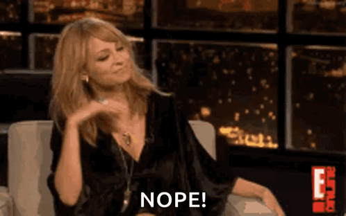 Woman In Black Dress Sitting Making Funny Face Saying Nope GIF