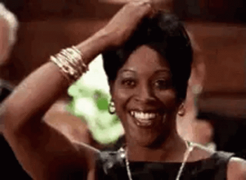 Woman in Black Dress Smiling and Holding Hair