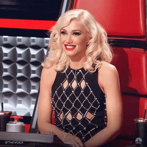 Woman In Black Dress Smiling In Red Chair GIF
