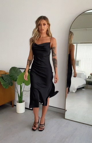 Woman in Black Dress Standing in Front of Mirror