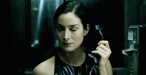 Woman in Black Dress Talking on Pay Phone