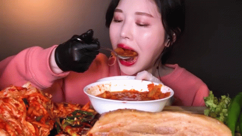 Woman In Black Gloves Eating Bowl Of Food GIF