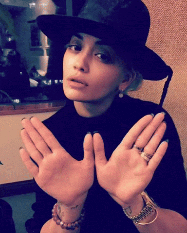 Woman In Black Hat And Bracelets Holding Hands Up GIF