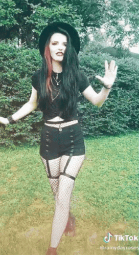 Woman in Black Hat and Fishnets in Grass