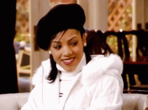 Woman in Black Hat and White Coat Smiles
