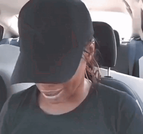 Woman in Black Hat Smiling in Back Seat of Car