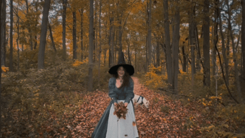 Woman in Black Hat Throwing Leaves in Forest