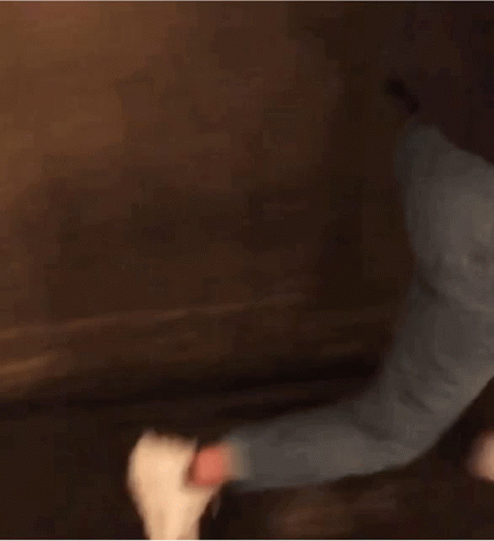 Woman in Black Jacket and Blue Jeans Walking Down Dark Hallway