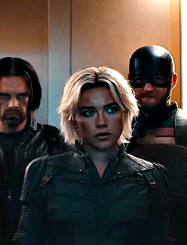 Woman In Black Jacket Next To Two Men GIF