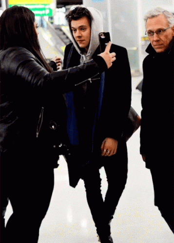 Woman in Black Jacket Photographing Man in Hoodie