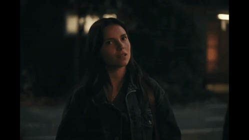 Woman in Black Jacket Standing in Darkness