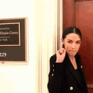 Woman In Black Jacket With Ocasio Cortez Sign GIF