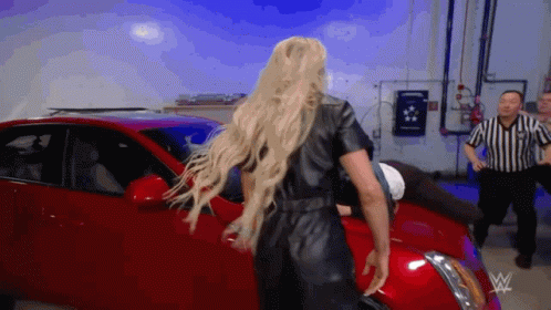 Woman in Black Leather Jumpsuit in Front of Red Car