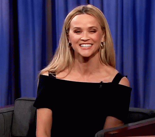 Woman In Black Off-Shoulder Top And Hoop Earrings Smiling GIF