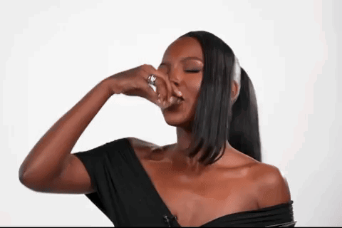 Woman in Black Off Shoulder Top Covering Nose With Hand