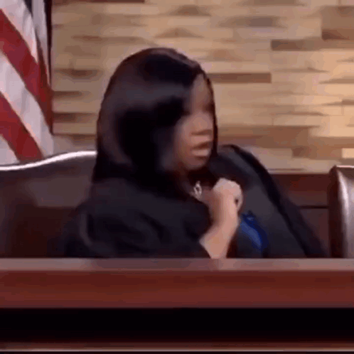 Woman in Black Robe Sitting at Courtroom Table