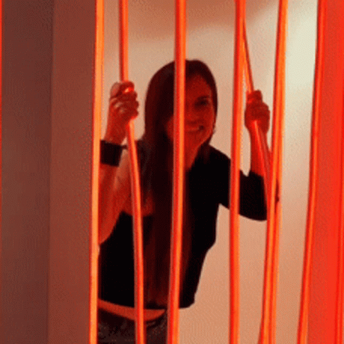 Woman in Black Shirt Behind Red Fence