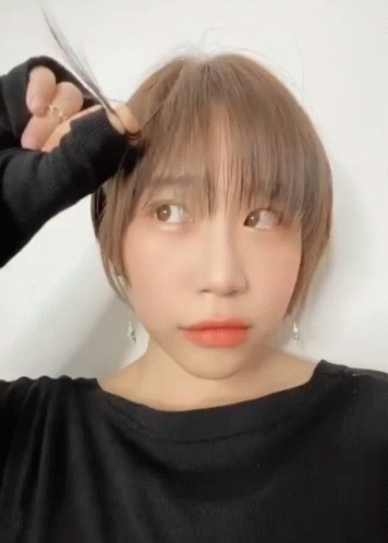 Woman In Black Shirt Cutting Hair With Scissors GIF