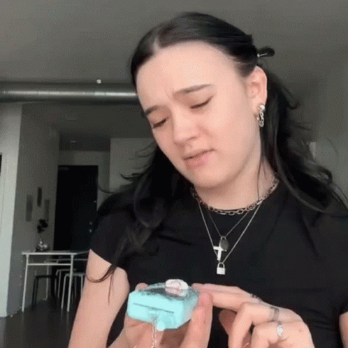 Woman in Black Shirt Holding Blue Item