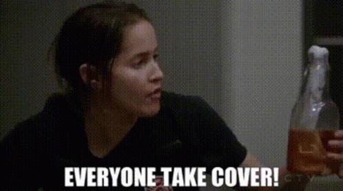 Woman in Black Shirt Holding Bottle Saying Everyone Take Cover