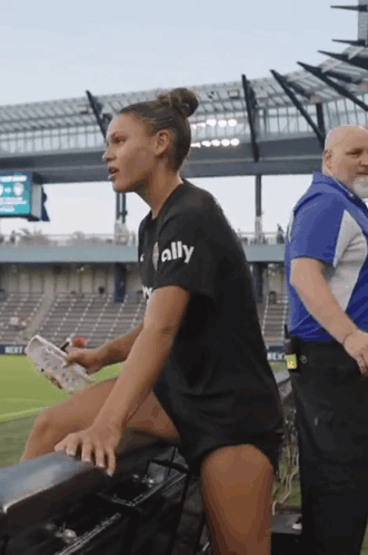 Woman in Black Shirt Saying Ally in Stadium