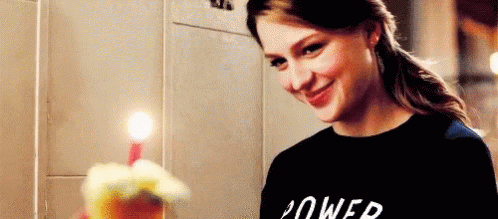 Woman In Black Shirt Smiling Holding Birthday Cake With Candle GIF