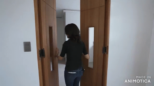 Woman in Black Shirt Walking Through Door