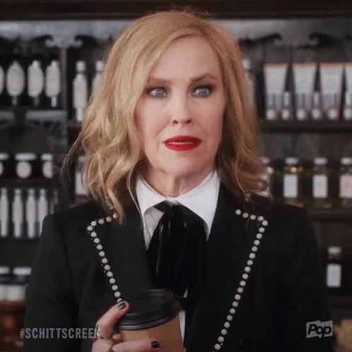 Woman In Black Suit Holding Coffee GIF