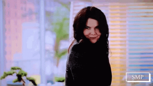 Woman In Black Sweater Smiling At Camera GIF