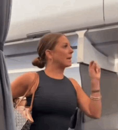 Woman In Black Tank Top Holding Purse In Airplane GIF