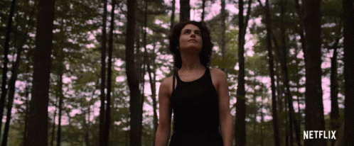 Woman In Black Tank Top In Forest With Netflix GIF