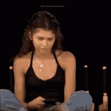 Woman In Black Tank Top Looking At Phone GIF
