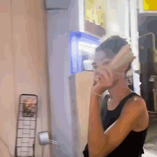 Woman In Black Tank Top Talking On Phone GIF