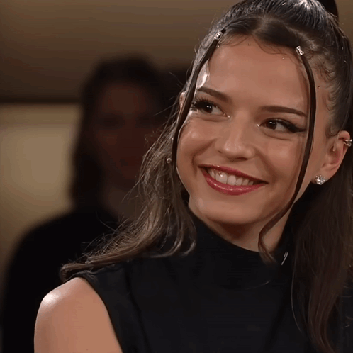 Woman In Black Turtleneck And Earrings Smiling GIF
