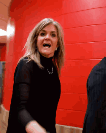 Woman in Black Turtleneck Screaming Before Red Wall