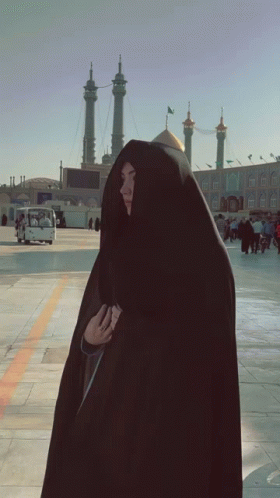 Woman in Black Veil Standing Before Building