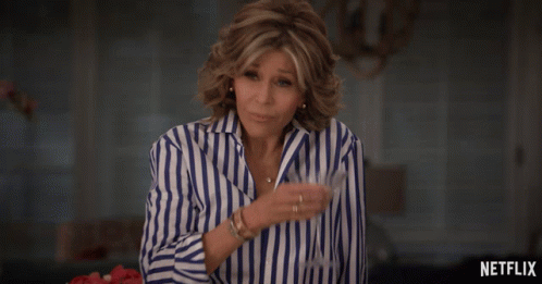 Woman in Blue and White Striped Shirt by Netflix Sign